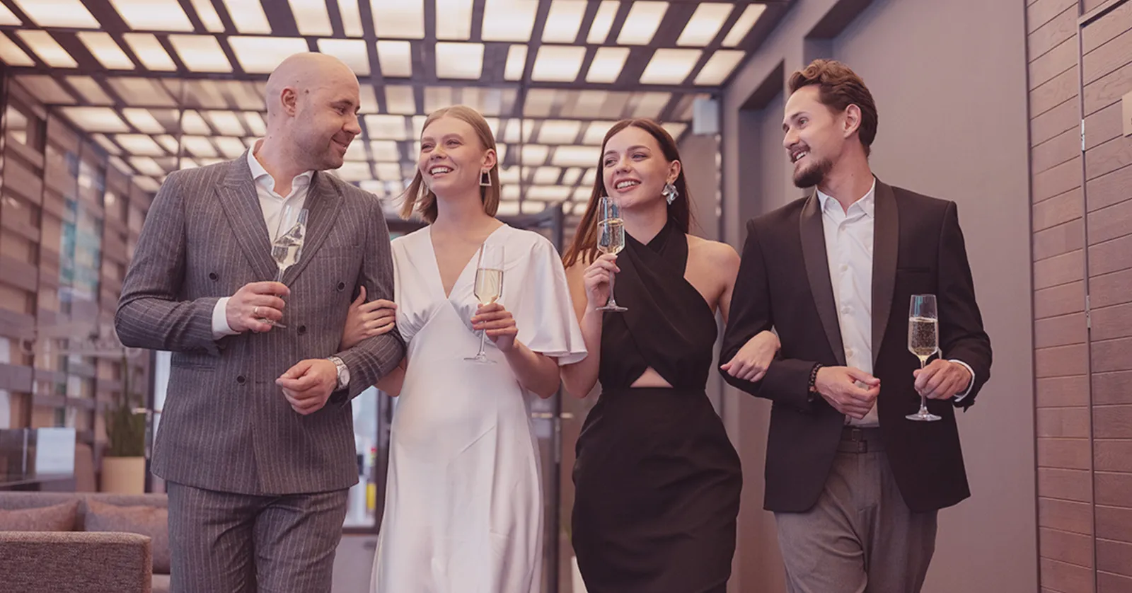 Elegant gruppe i formell bekledning med champagne, som symboliserer vårt kundecase i billettsalg på nett.
